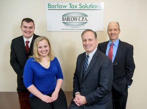 Barlow team in front of sign